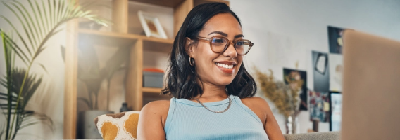 Student wearing glasses working on her laptop